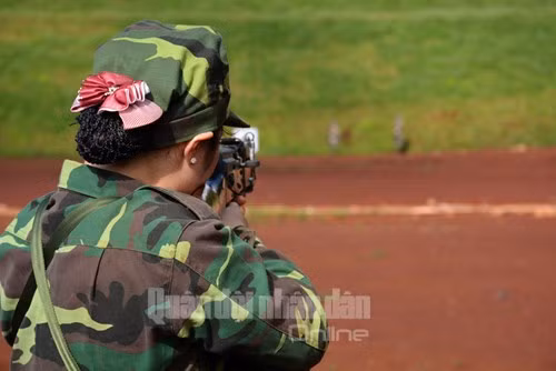 Một nữ xạ thủ với đường ngắm chính xác trong tư thế đứng bắn.