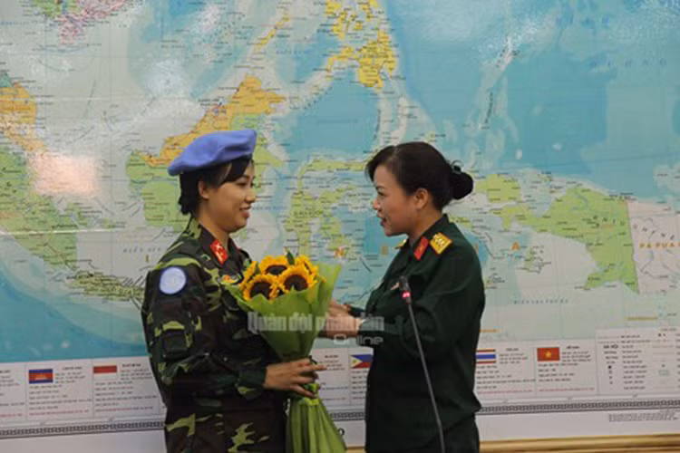 Thượng tá Nguyễn Thị Oanh, Phó trưởng ban Phụ nữ Quân đội tặng hoa chúc mừng Thiếu tá Đỗ Thị Hằng Nga khi nhận nhiệm vụ mới.