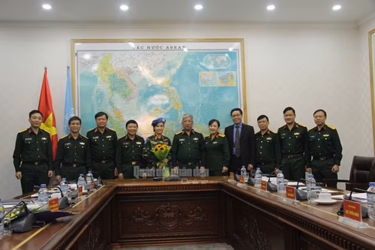 Thiếu tá Đỗ Thị Hằng Nga chụp ảnh cùng Thủ trưởng Bộ Quốc phòng, đại diện Bộ Ngoại giao, đại diện Cục Đối ngoại, Cục Cán bộ, Cục Tuyên huấn và lãnh đạo Trung tâm GGHB Việt Nam.