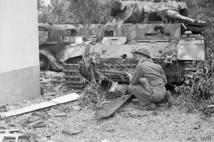 Người lính nấp phía sau một chiếc xe tăng Đức đã bị bắn cháy ở Oosterhout vào ngày 24/9/1944.
