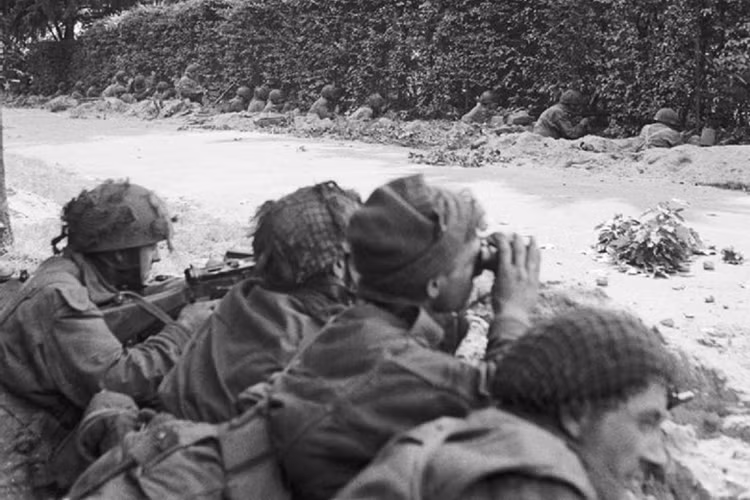 Binh sĩ đại đội C, tiểu đoàn 1, trung đoàn Biên giới (quân Đồng minh), đợi sẵn trong các rãnh bên đường, sẵn sàng đẩy lui đối phương đang ở cách đó chỉ 91m.
