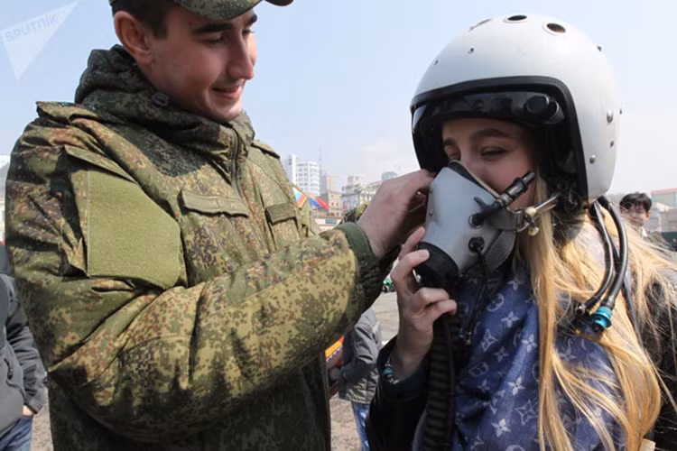 Một cô gái được thử mũ bảo hiểm của phi công tại triển lãm thiết bị quân sự ở Vladivostok, Nga, tháng 4/2015.