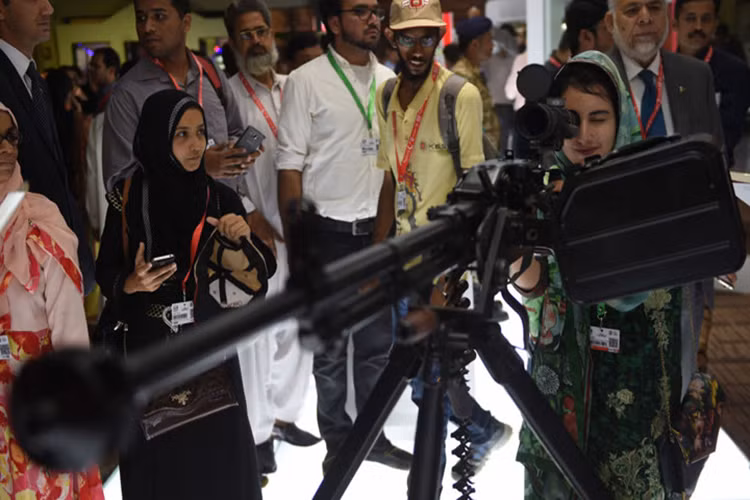 Một khách tham quan nữ thậm chí còn kiểm tra khá kĩ chiếc súng máy được trưng bày tại Hội thảo và Triển lãm quốc phòng quốc tế ở Karachi, Pakistan, tháng 11/2016.