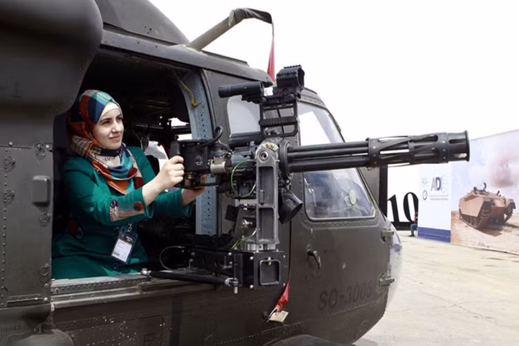 Một phụ nữ thử cảm giác ngắm bắn với súng máy gắn trên trực thăng trong Hội thảo và Triều lãm các lực lượng đặc nhiệm ở Amman, Jordan, hồi tháng 5/2014.