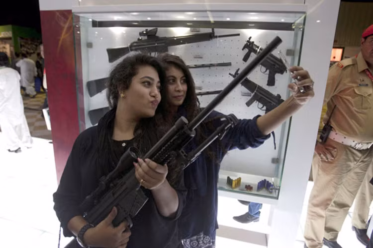 Hai cô gái trẻ tự hào chụp ảnh cùng một loại vũ khí do Pakistan tự chế tạo tại triển lãm quốc phòng quốc tế ở Karachi tháng 11/2016.