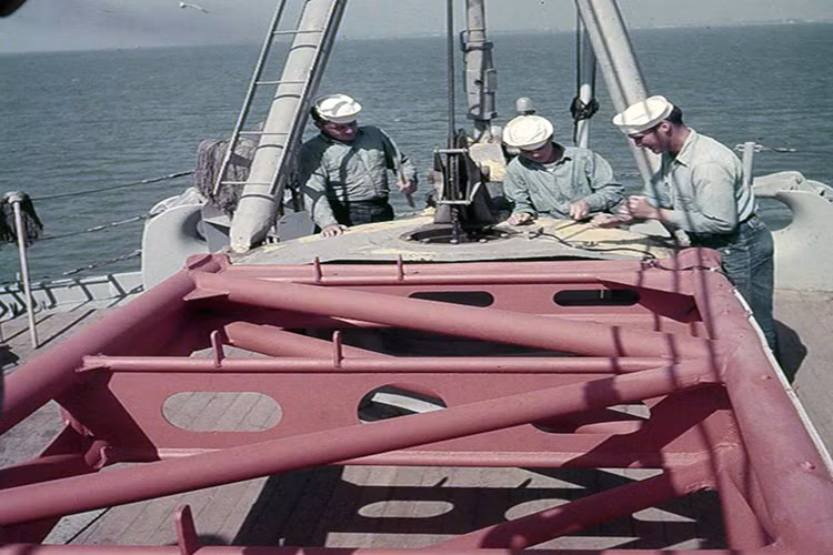 Một cần cẩu trên USS Iowa được thủy thủ sơn mới lại với lớp sơn chống rỉ màu đỏ trước khi sơn lại màu xám màu ngụy trang đặc trưng của các tàu chiến Mỹ lúc này. Nguồn ảnh: WW2 Radio.