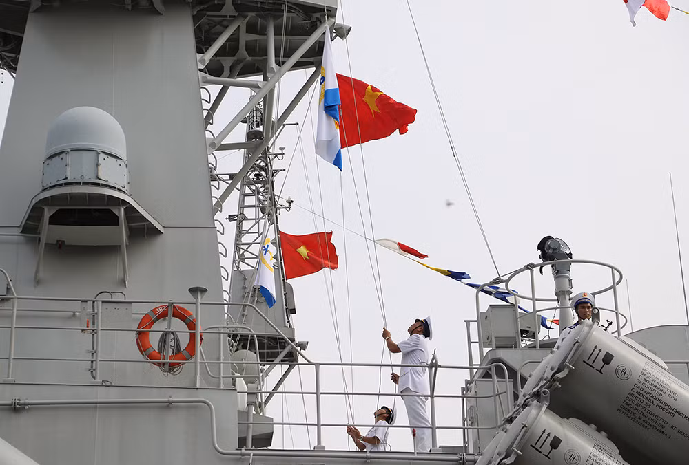 Thuyền trưởng và chính trị viên Tàu 382 kéo Quốc kỳ và Cờ Hải quân trong Lễ thượng cờ.