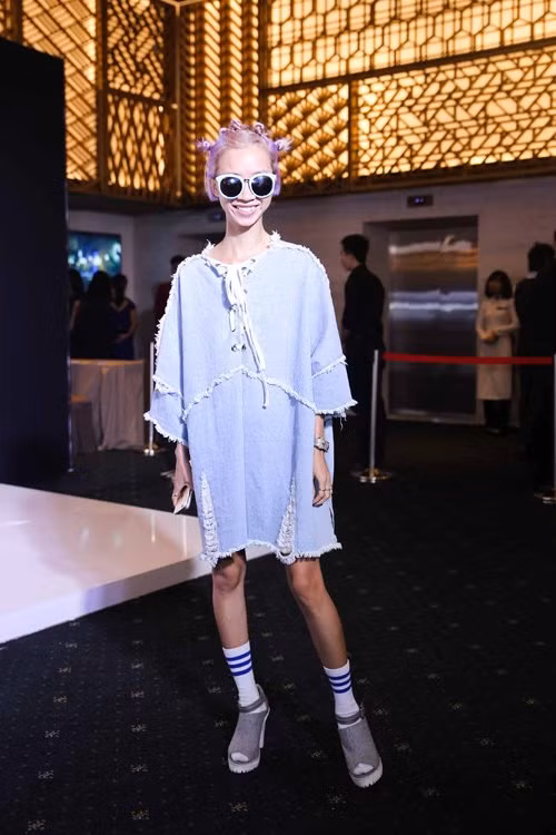 Cô gái cá tính với mái tóc tím và bộ cánh xanh te tua.