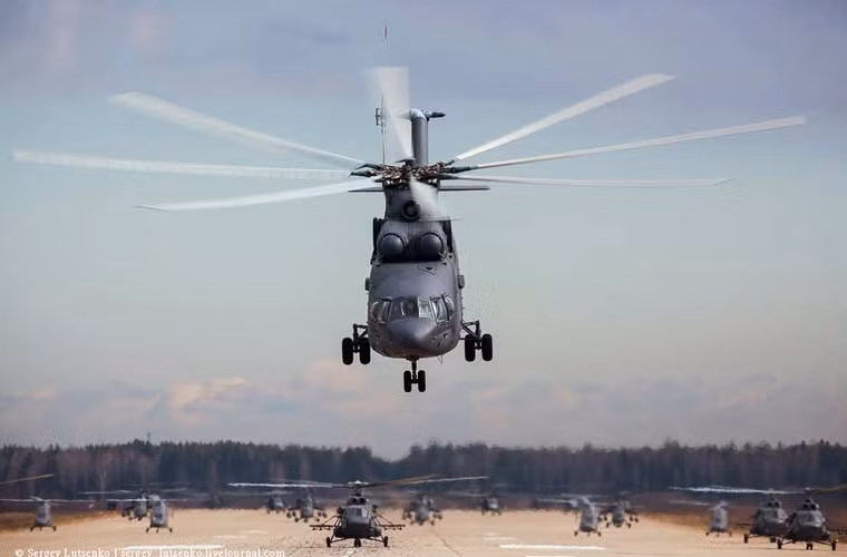 Đội hình hợp luyện trực thăng Không quân Nga cất cánh, có thể nhận ra gương mặt quen thuộc – trực thăng vận tải lớn nhất thế giới Mi-26 dẫn đầu, tiếp đó trực thăng vận tải/tấn công Mi-8AMTSh, trực thăng tấn công Mi-35, Mi-28, Ka-52…