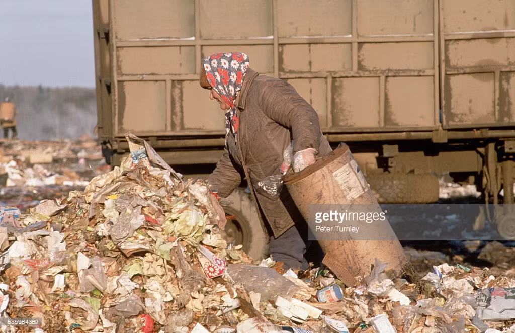 Người phụ nữ tìm kiếm thực phẩm tại bãi rác ở ngoại ô.