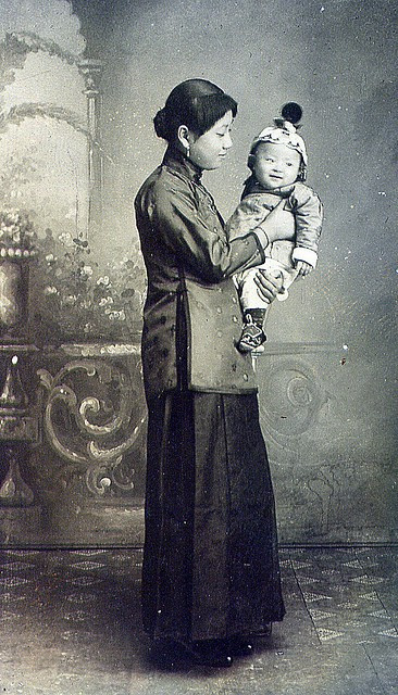 Người mẹ với ánh mắt trìu mến, đầy ắp tình yêu thương khi bế con trai nhỏ trong tay.