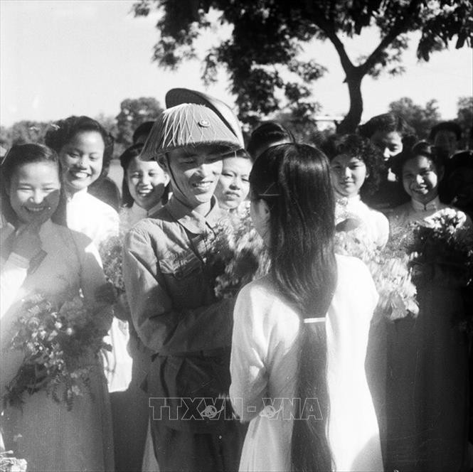 Thiếu tướng Vương Thừa Vũ, Tư lệnh Đại đoàn 308, Chủ tịch Ủy ban Quân chính Thành phố giữa vòng vây của các nữ sinh trường Trưng Vương tặng hoa chúc mừng bên hồ Hoàn Kiếm trong ngày Giải phóng Thủ đô. Nguồn TTXVN.