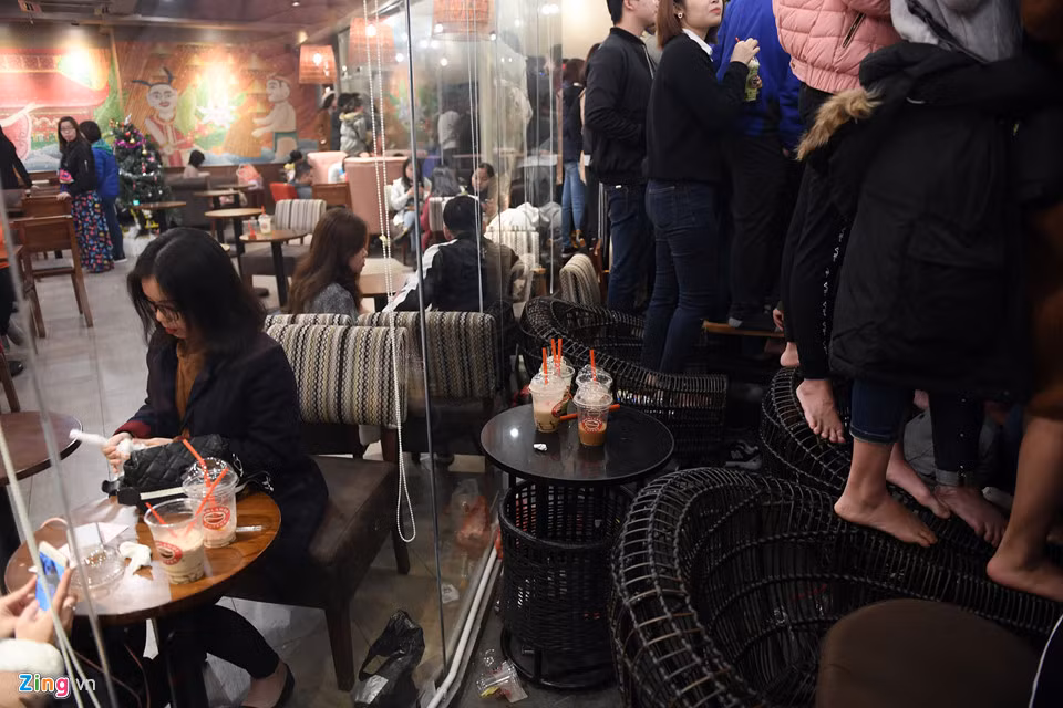 Trong quán, nhiều người đứng cả trên ghế để nghe thần tượng hát.