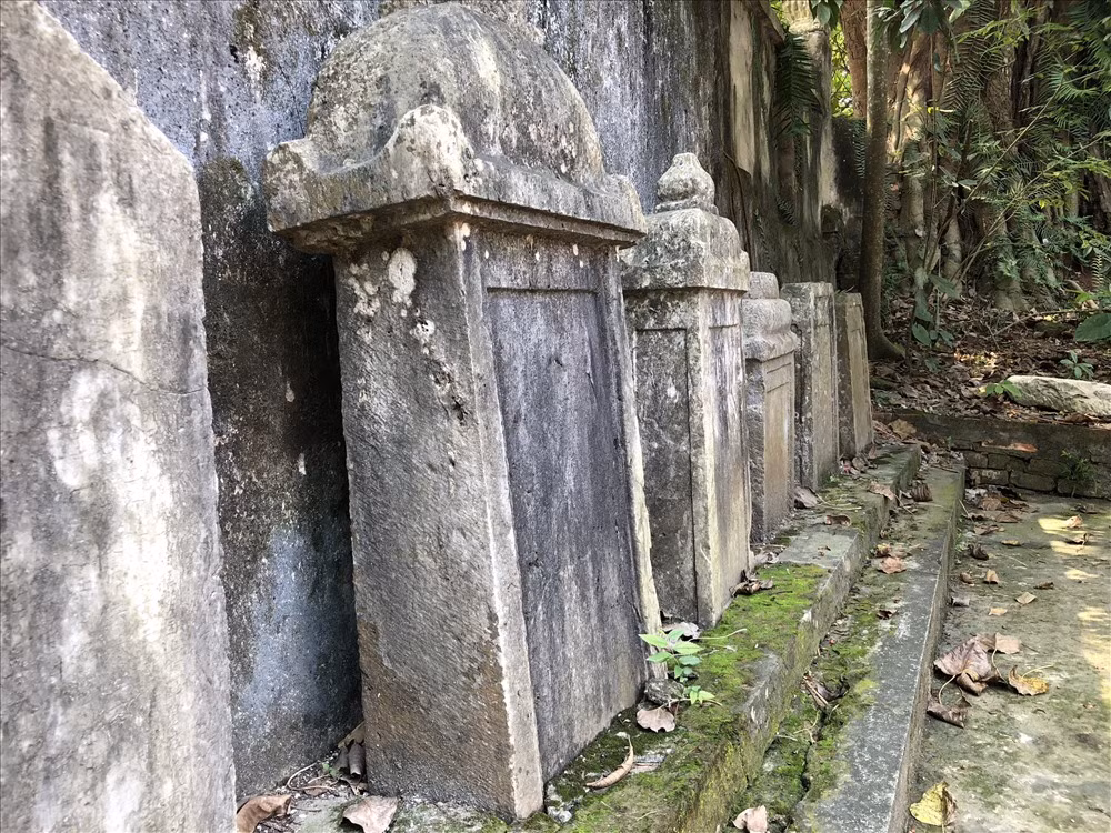 Những tấm bia đá đã mờ chữ được xếp dọc tường bao ngay mặt trước ngôi chùa.