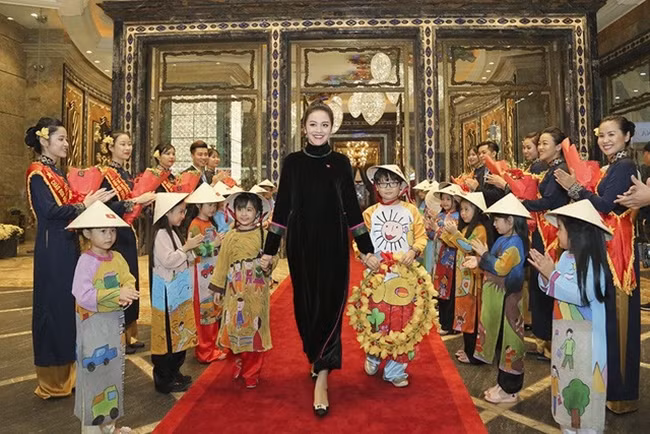 Bà xã sinh năm 1988 của nhạc sĩ Thanh Bùi diện áo dài đen đón tiếp HLV Park Hang-seo cùng các tuyển thủ đội tuyển U23 Việt Nam tại Khách sạn The Reverie Saigon, nhân dịp đội tuyển có chương trình giao lưu tại TP.HCM với người hâm mộ vào đầu tháng 2.2018.