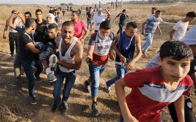 Một người biểu tình Palestine bị thương sau khi trúng đạn của binh sĩ Israel ở gần khu vực biên giới Israel và Dải Gaza hôm 13/10.