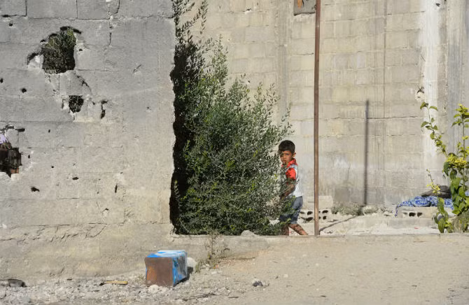 Một người dân địa phương trên đường phố giữa những tòa nhà bị phá hủy tại khu vực Dahane ở Damascus.