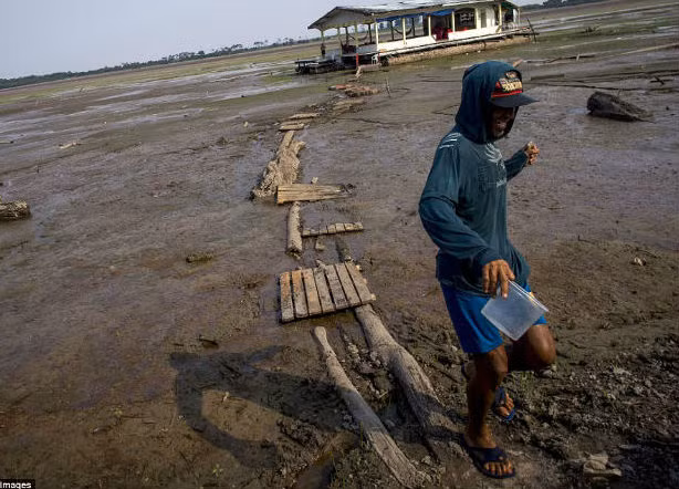 Con đường dẫn tới ngôi nhà của người đàn ông này từng ngập trong nước nhưng giờ đây chỉ toàn bùn đất do ảnh hưởng của đợt hạn hán kéo dài.