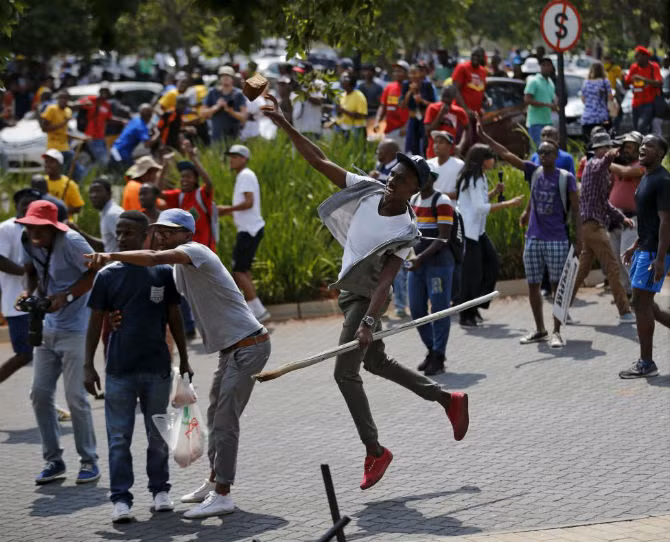 Sinh viên ném đá về phía cảnh sát Nam Phi bên ngoài trường Đại học Johannesburg ngày 22/10.