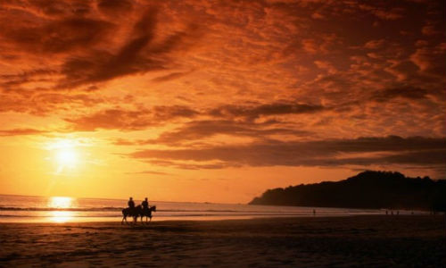 Mặt trời đang chiếu những tia nắng cuối cùng trong ngày trên bãi biển Manuel Antonio, Costa Rica.