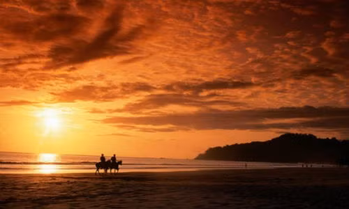 Mặt trời đang chiếu những tia nắng cuối cùng trong ngày trên bãi biển Manuel Antonio, Costa Rica.