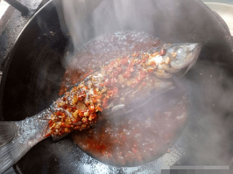 Bước 7: Cho cá vào, vặn lửa nhỏ và đun từ từ, dùng thìa rưới nước ngập mặt cá để gia vị ngấm đều hơn. Sau 5 phút, lật mặt cá và tiếp tục rưới nước sốt lên cá. (Ảnh: ABLW)