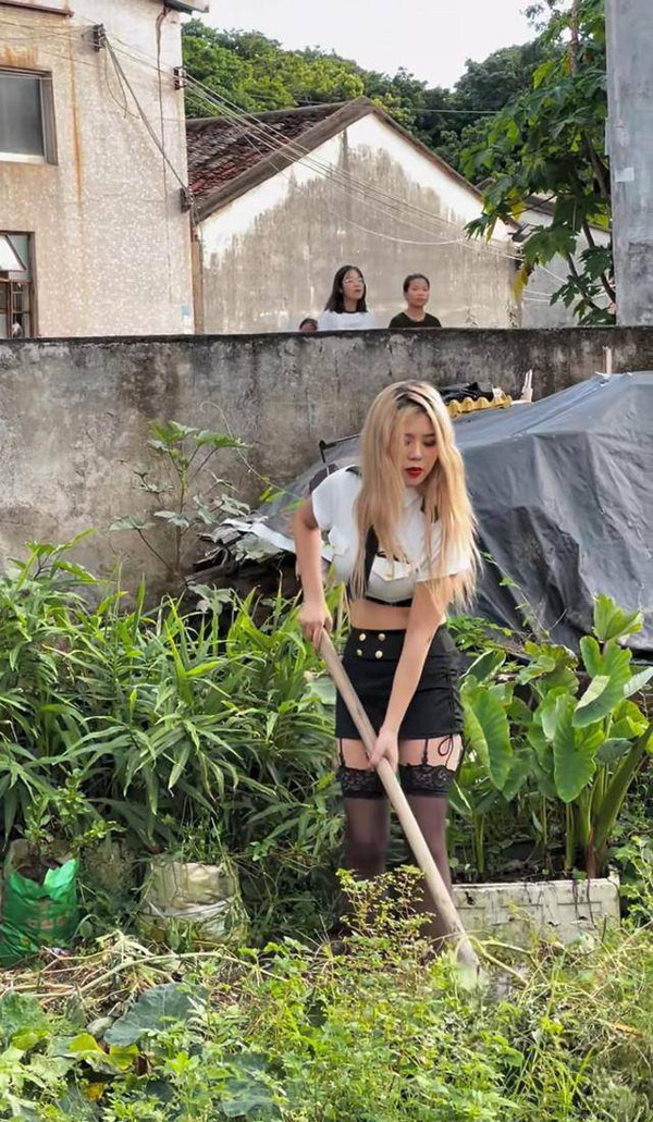 Ngay khi về làng, Tiểu Nữ gây sự chú ý bởi mái tóc tẩy trắng, gương mặt trang điểm đậm. Không những vậy, cô gái còn ăn mặc khá mát mẻ. Cụ thể, Tiểu Nữ diện một cây đen ôm sát. Điểm nhấn của bộ đồ là chiếc áo croptop hở rốn, khoe eo thon gọn. Phần thân dưới kết hợp hotpants, quần tất và bốt cổ cao.