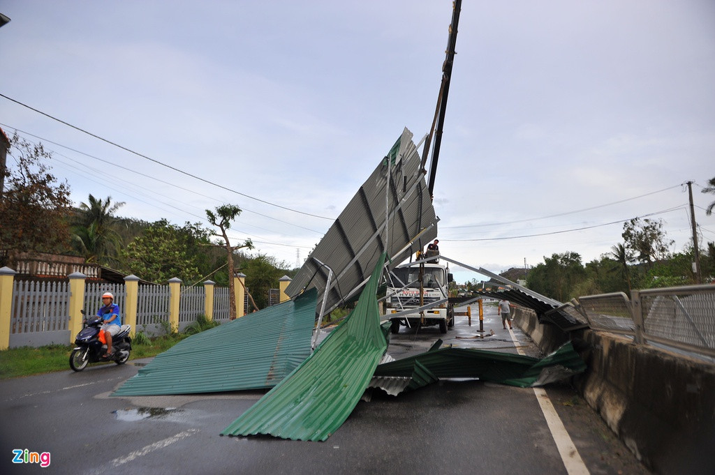 Một làn đường bị phong tỏa. Xe cộ phải di chuyển trên làn đường còn lại trong lúc chờ lực lượng chức năng di dời những tấm tôn này.