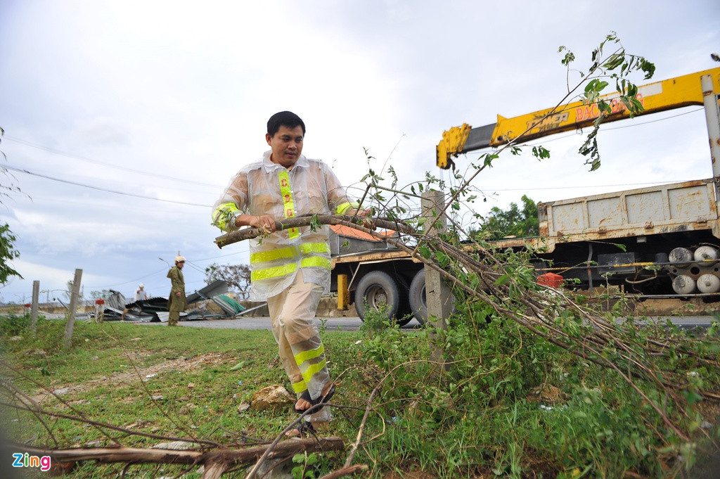 Các cành cây chắn ngang đường được cảnh sát giao thông di chuyển, đảm bảo thông tuyến quốc lộ 1.