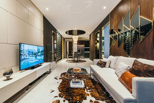 Phòng khách chính sử dụng hai tông màu tương phản gồm màu trắng tinh khiết và màu nâu gỗ đậm nét làm nên vẻ sang trọng hiện đại của căn nhà. Bàn và ghế sofa có chân đỡ làm cho không gian thoáng hơn.