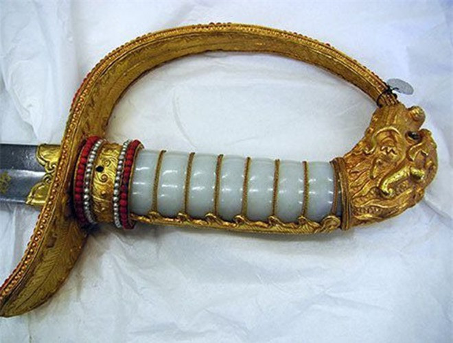 Thanh kiếm gồm 2 phần: lưỡi kiếm dài khoảng 1 m và chuôi kiếm dài bằng 1/5 lưỡi kiếm. Phía cuối phần cánh đốc kiếm có chạm trổ hình những chiếc lá bằng vàng và nạm nhiều hạt kim cương. Đây là thanh kiếm bảo kiếm của vua Gia Long, vốn được trưng bày trong Đại Nội Huế, nhưng bị người Pháp cướp đi sau vụ “Kinh đô thất thủ” vào tháng 7-1885. Ảnh: Dominique Rolland