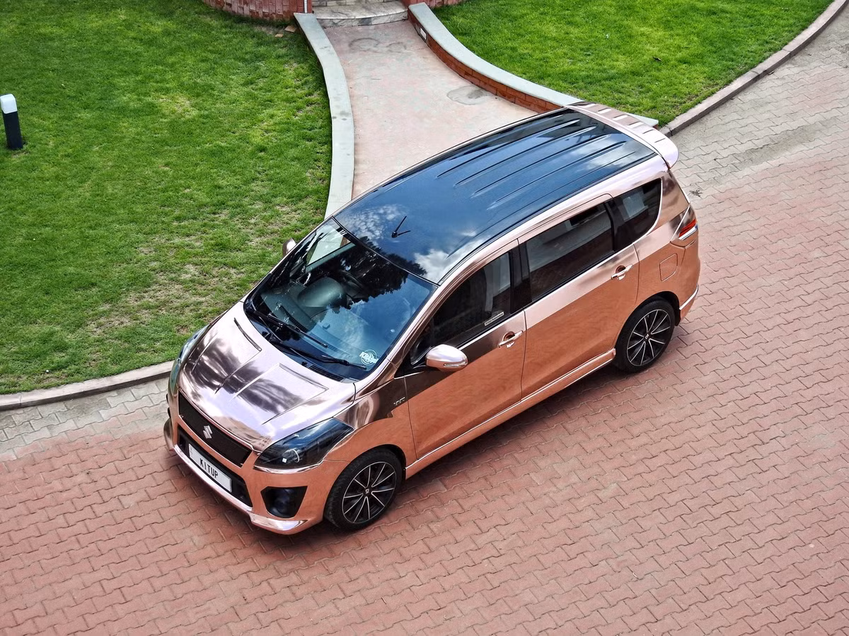 So với bản tiêu chuẩn, bản độ Maruti Ertiga dường như đã “lột xác” hoàn toàn với lưới tản nhiệt được ốp nhựa màu đen, phía trên là dải nhựa bản rộng được gắn logo chữ “S” của Suzuki. Các hốc gió cỡ lớn tích hợp đèn sương mù kép độc đáo. Cản trước cũng được thiết kế lại mở rộng hơn.