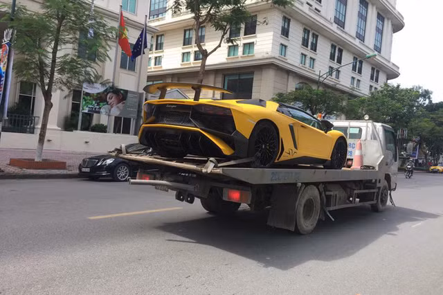Một hình ảnh khác lại cho thấy siêu xe Lamborghini Aventador SV mui trần nằm trên xe chuyên dụng để vận chuyển trên phố Hà Nội cũng trong sáng nay.
