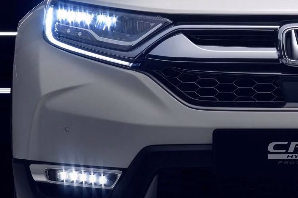 Thiết kế phía trước của Honda CR-V hybrid nổi bật với phần đầu lớn, bộ lưới tản nhiệt dạng lưới nằm dưới thanh ngang mạ crôm sáng bóng, cụm đèn pha LED chiếu sáng ban ngày, đèn sương mù dạng thanh ngang nằm trên cản trước đối xứng khá bắt mắt.
