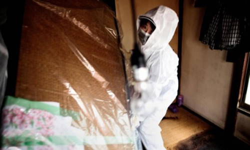 Nhân viên dịch vụ dọn dẹp căn hộ của người đàn ông tự sát tại Tokyo. Ảnh: AFP.