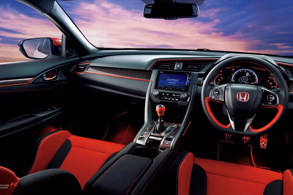 Khác với các chi tiết khác trên xe, chất liệu trên cánh gió này không đồng bộ với những nơi khác, bởi carbon ở những bộ phận khác là nhân tạo. Ở bên trong, khoang nội thất cũng được làm lại với độ chịu chơi cũng không hề thua kém khi hãng độ xe Modulo trang bị cho chiếc Honda Civic Type R viền carbon phủ sơn đỏ.