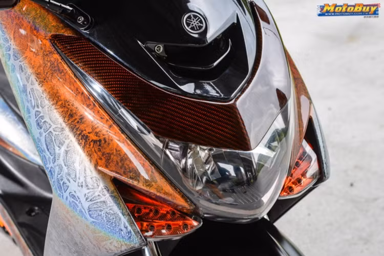Phần thân vỏ được sơn đổi màu theo góc nhìn kèm hoa văn graphic độc đáo, bên cạnh đó là các chi tiết nhựa được sơn phủ carbon fiber với màu sơn cam. Gương xe cũng được sơn carbon và được thay thế bằng loại của TMAX 530.