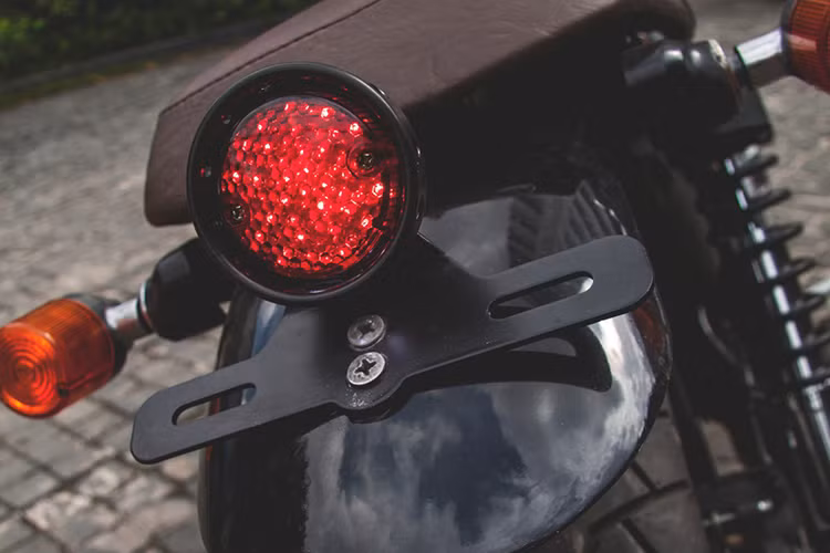 Phía sau, cụm đèn hậu lớn cũng đã được độ lại với đèn Stop LED tròn, nhỏ gọn đặt ngay trên chắn bùn chính của xe. Dè sau cũng được cắt gọn hơn thể hiện cá tính, pad biển số nâng cao sát cụm đèn hậu dạng led.