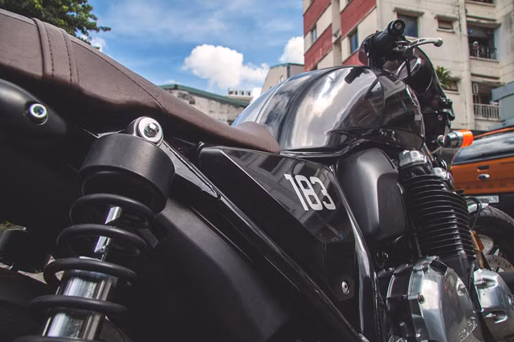 Bản độ CB1100 này được người thợ chọn gam màu đen chủ đạo, kết hợp cùng những chi tiết sáng bóng ánh kim loại, yên xe làm thủ công màu da bò, đậm nét cổ điển không kém phần cuốn hút. Đặc biệt, trên chi tiết ốp xuất hiện con số 183, mang một ý nghĩa tháng, năm sinh của nữ chủ nhân.