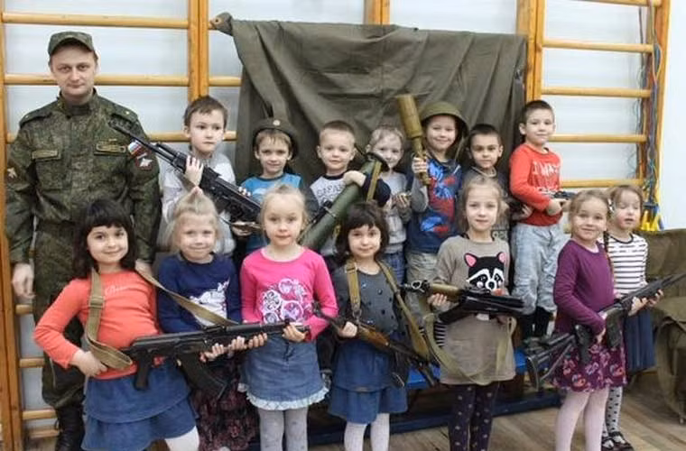 Các em bé Nga tỏ ra rất thích thú với những khẩu súng trường, súng phóng lựu trong chuyến thăm doanh trại quân đội.