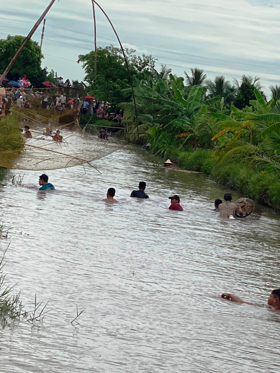 Những người đàn ông ngụp lặn dưới sông để bắt cá.