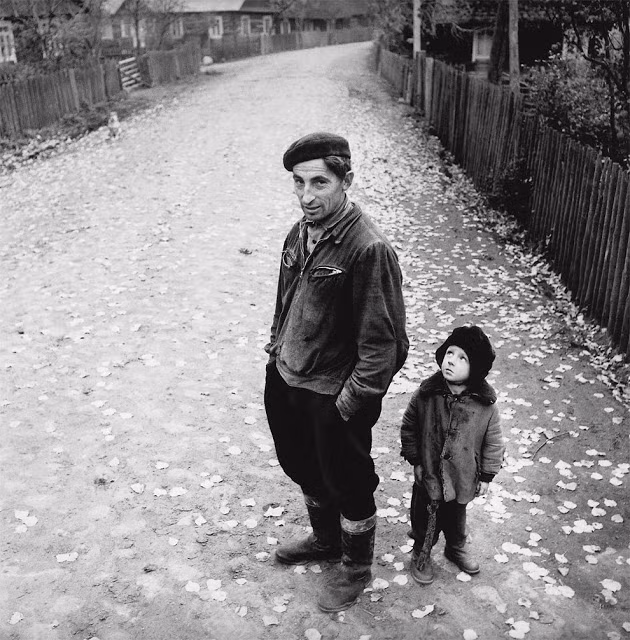 Người đàn ông Lithuania và bé trai đứng trên con đường làng vắng người. Ảnh VT