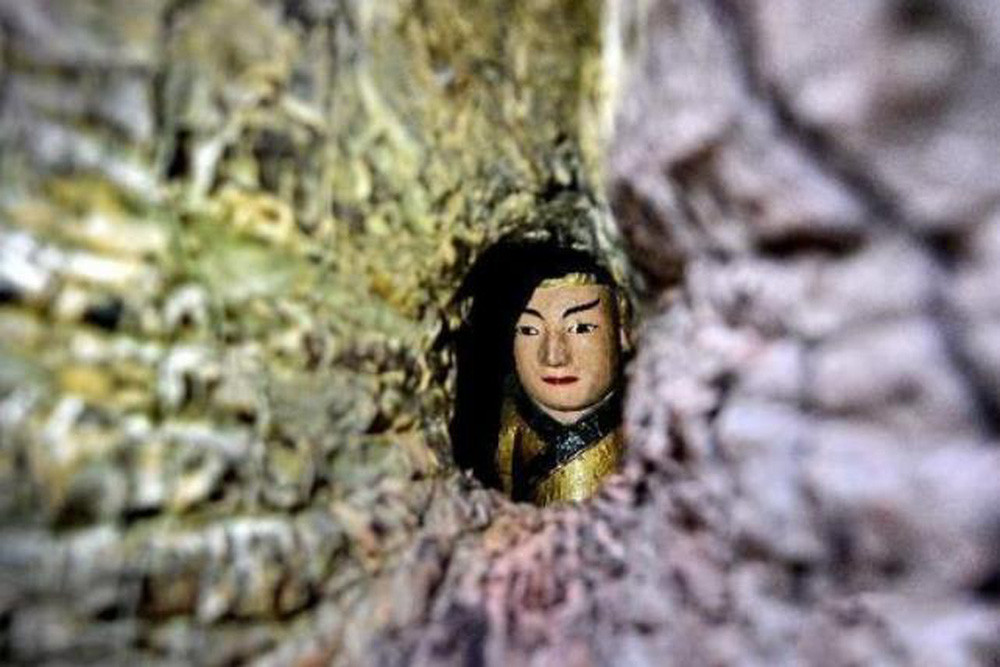 Ở giữa thân cây có một lỗ nhỏ với kích thước tương đương một bàn tay người. Khi nhìn qua lỗ này, mọi người có thể thấy bức tượng đặc biệt trên.