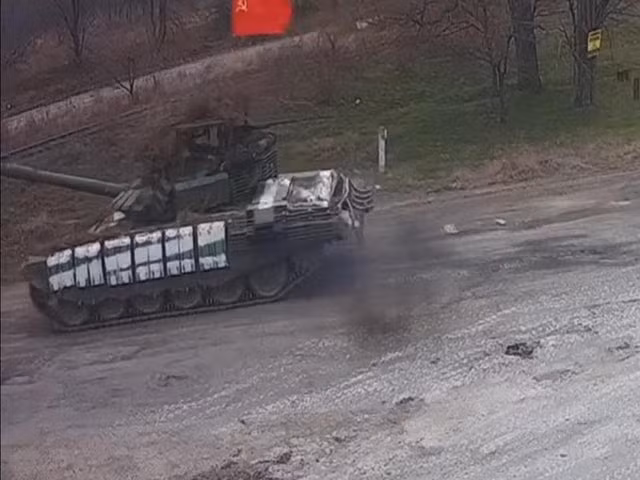 Trong đoạn video được camera an ninh ghi lại gần khu vực biên giới phía Bắc Ukraine, một chiếc xe tăng chủ lực của Nga, đã treo lá cờ đỏ Liên Xô dẫn đầu đoàn quân.