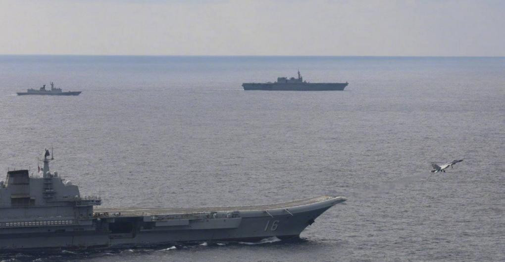 Trong ảnh, chiếc tàu Nhật Bản di chuyển ở mạn trái tàu Liêu Ninh, trong khi tiêm kích J-15 cất cánh từ boong tàu sân bay Trung Quốc.