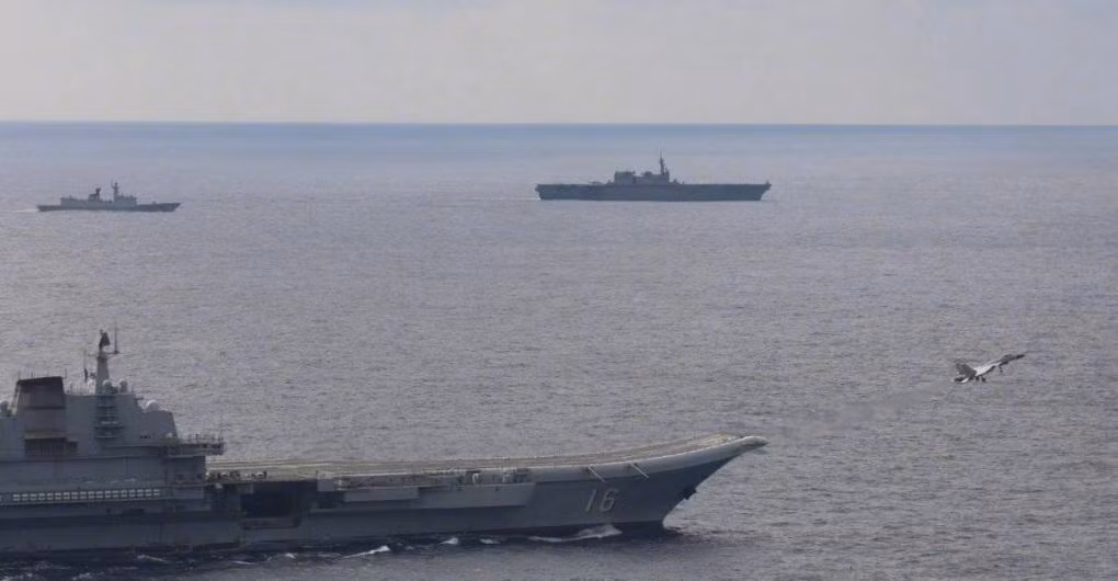 Trong ảnh, chiếc tàu Nhật Bản di chuyển ở mạn trái tàu Liêu Ninh, trong khi tiêm kích J-15 cất cánh từ boong tàu sân bay Trung Quốc.
