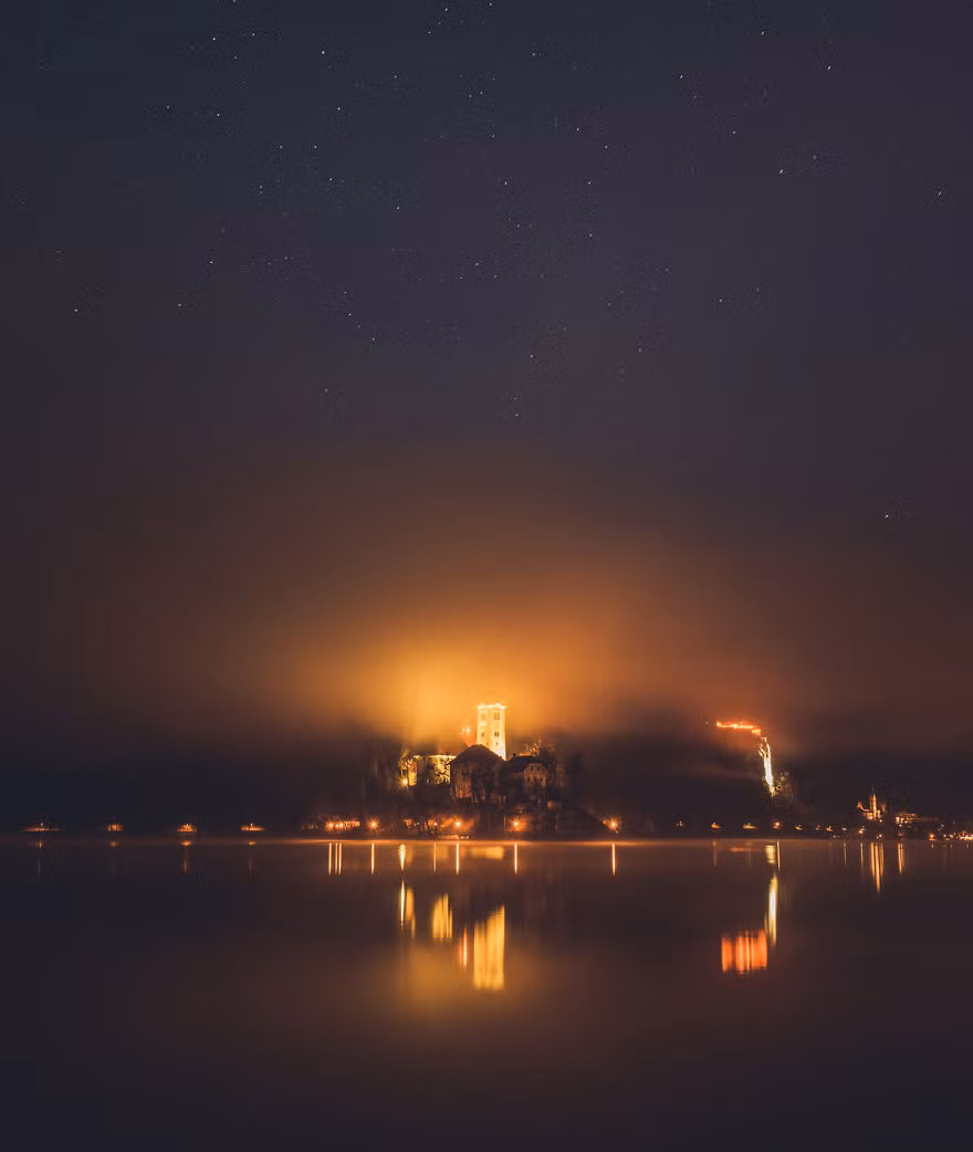 Nhà thờ trên đảo nổi tỏa ra một ánh sáng thần thánh dưới bầu trời đầy sao ở hồ Bled.