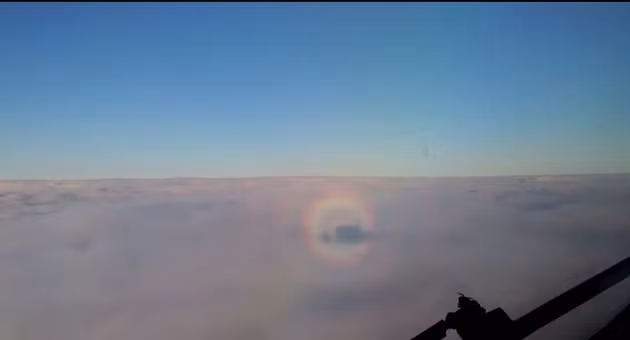 Khoảnh khắc máy bay tiến gần đến vòng hào quang kỳ ảo trên bầu trời.