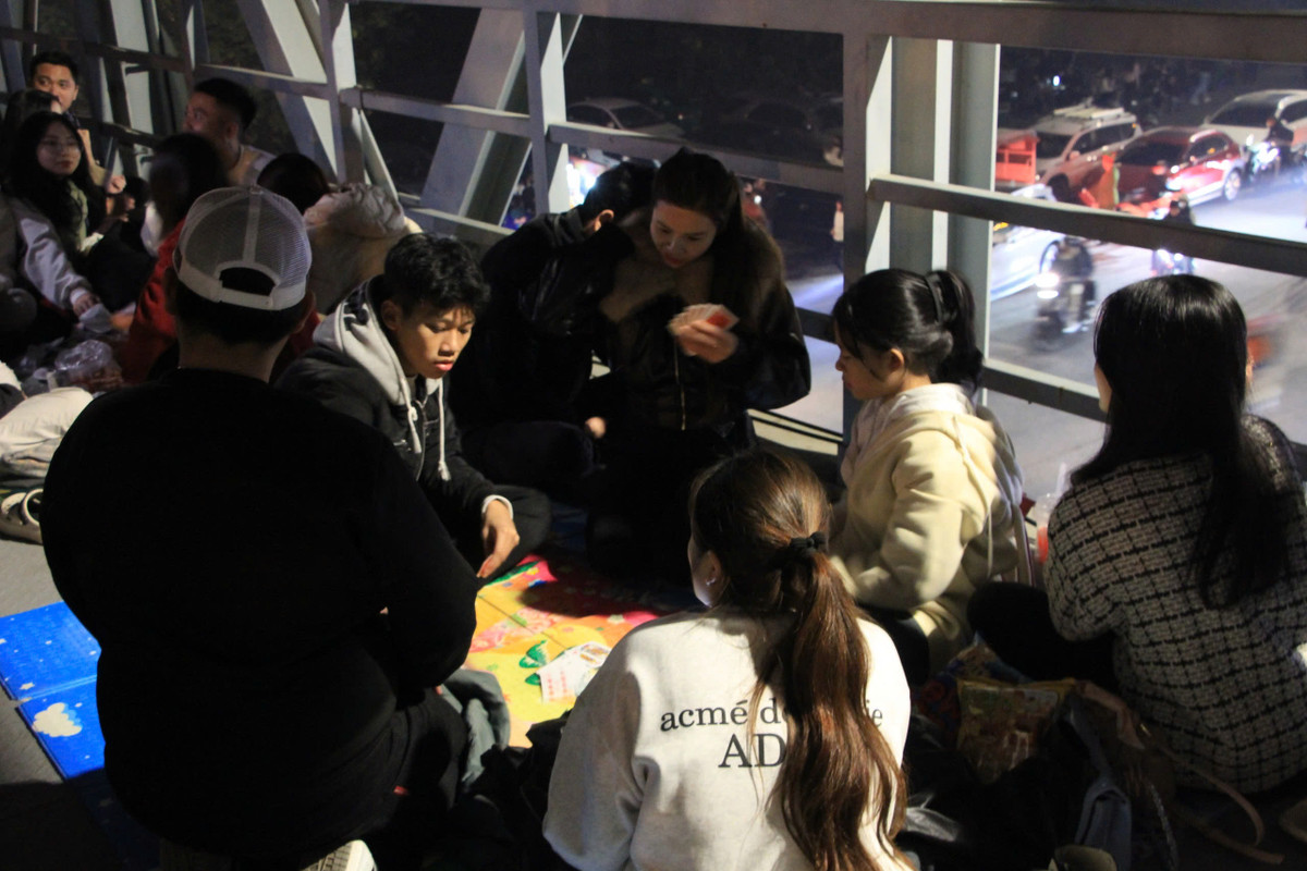 Trong lúc chờ pháo hoa, nhóm bạn trẻ giải trí bằng trò đánh bài.