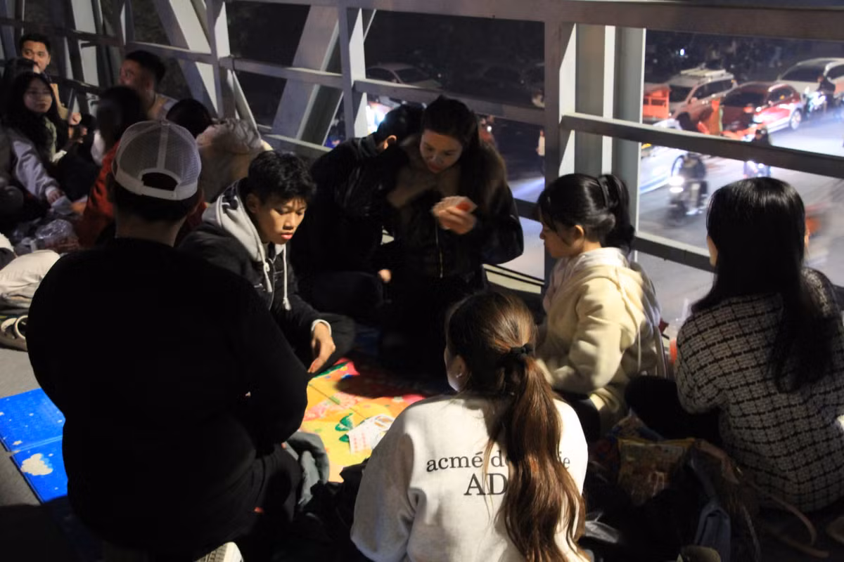 Trong lúc chờ pháo hoa, nhóm bạn trẻ giải trí bằng trò đánh bài.